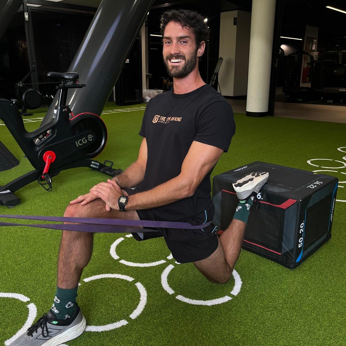 Personal trainer stretching in an outdoor space using equipment