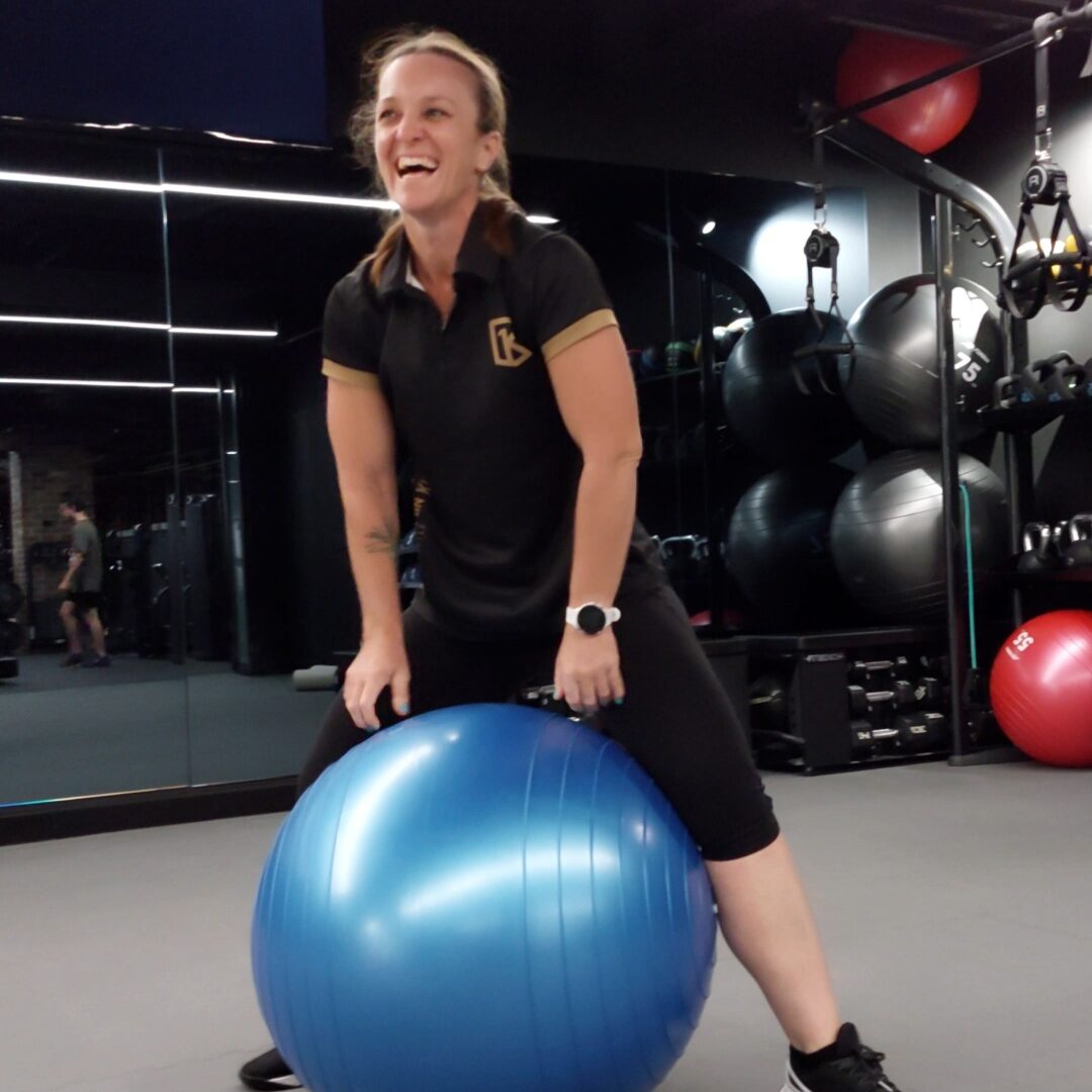 Female trainer in the gym using exercise ball